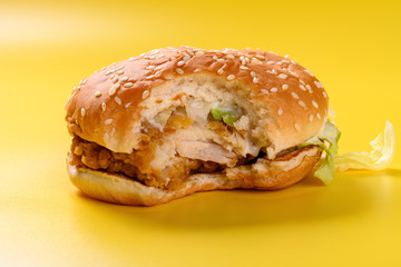hamburger with a bite on a yellow background