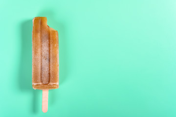 red bean popsicle with a bite on light green background