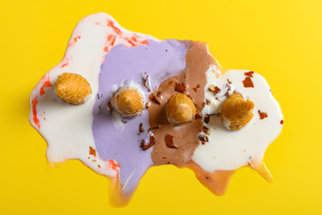 top view multiple flavor ice cream cones melted on yellow background