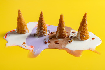 side view multiple flavor ice cream cones melted on yellow background