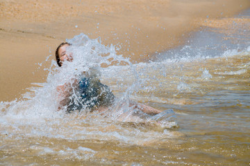 Happy child running in the waves during summer vacation on beach on ocean coast Little girl learning to swim.