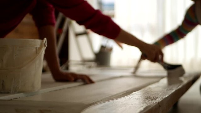 ドアのペンキを塗りなおす女性たち