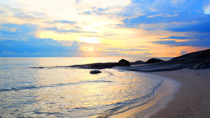 Obraz premium Sunrise on pastel color cloud sky at tropical sand beach with reef in the morning on rain season.