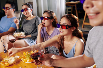 Group of young in people in 3D glasses watching captivating movie online in backyard