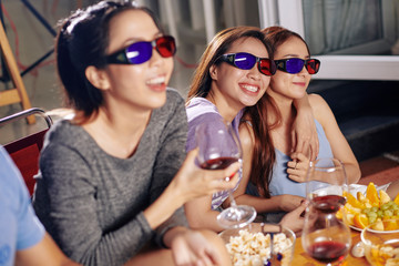 Beautiful pretty Asian woman in 3D glasses hugging when watching comedy movie in backyard with friends
