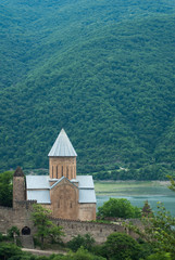 Fototapeta na wymiar View of the mountain Church. The ancient fortress Ananuri, Alpine landscape of the Church in Georgia,