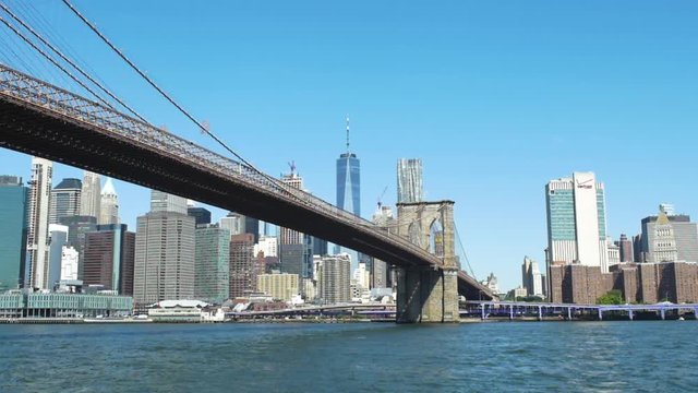 Slow motion looking across East River at Brooklyn Bridge and downtown Manhattan