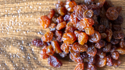 Dried raisins or kismis on wooden background.