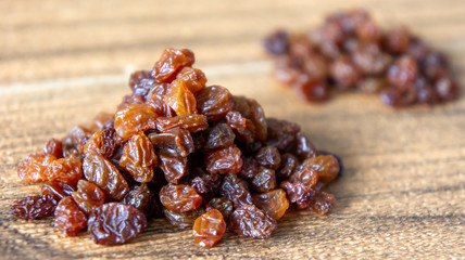 Dried raisins or kismis on wooden background.