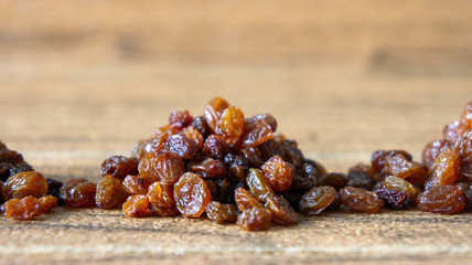 Dried raisins or kismis on wooden background.
