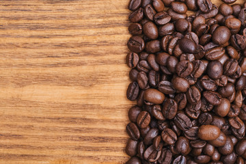 Coffee bean. The background of roasted coffee beans is brown on wooden boards. layout. Flat lay.