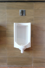 White urinals in the men's bathroom of interior decoration.