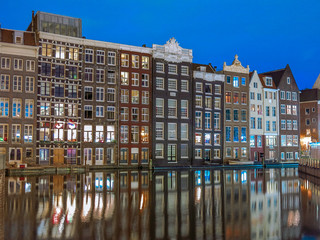 Historic houses reflecting off the water taken in Central, Amsterdam during the evening blue hour.