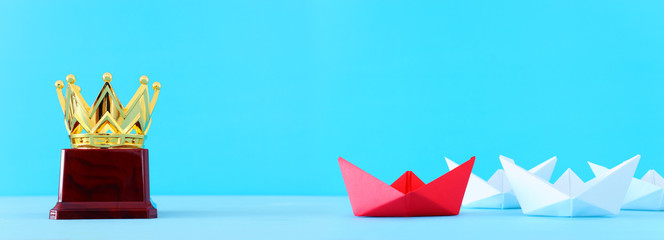 business. Leadership concept image with paper boats on blue wooden background. One leader guiding othes.