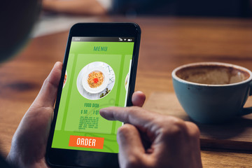 Close up woman hand holding food online mobile apps with hot coffee cup on table sitting at coffee shop,online order concept