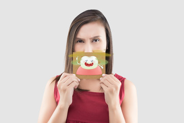 Asian woman in the red shirt holding a brown paper with the yellow teeth cartoon picture of his...