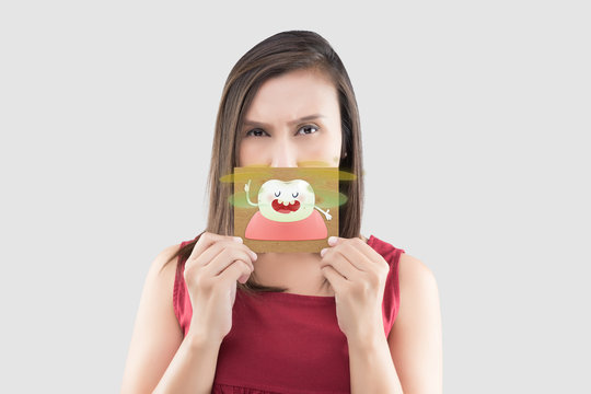 Asian woman in the red shirt holding a brown paper with the yellow teeth cartoon picture of his mouth against the gray background, Bad breath or Halitosis, The concept with healthcare gums and teeth