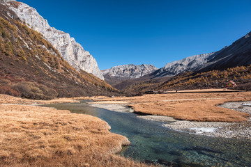 Sacred tibetan mountain with golden meadow and river in autumn