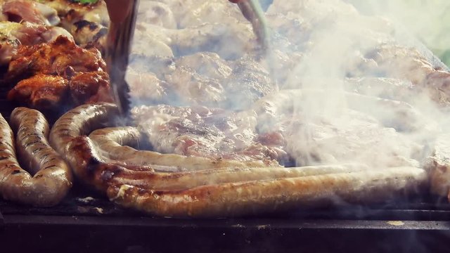 Grilled Sausage On The Flaming Grill. Bearbeque Outdoors with other meat on it, pork, chicken, mititei