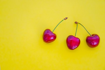 ripe red cherries isolated on a yellow background