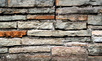 Old grungy Textured brick wall of old rectangle red and grey bricks.