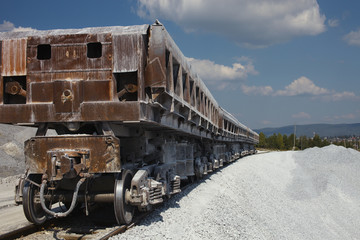 Railway dump-car back view close-up. Mining industry. Quarry and mining equipment.