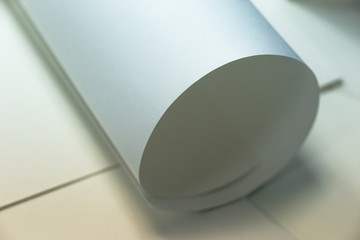 White paper, partially rolled up, close-up.Paper background, texture paper.