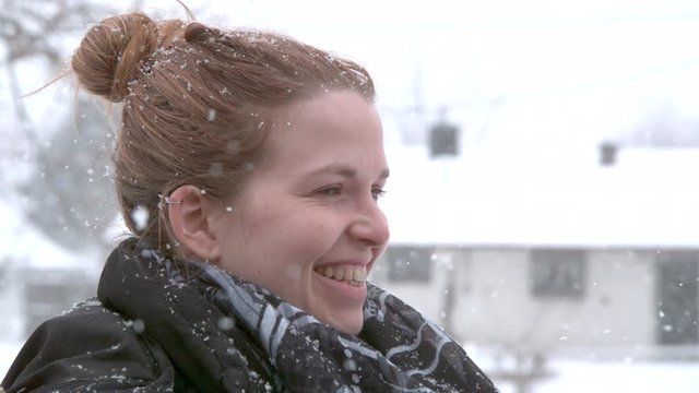 Smiling girl in snow fall slow motion