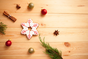 Christmas ginger bread - snowflake, mitten, hat with cinnamon, cardamom, pine, balls on light wooden background with copyspace. Top view, flat lay.