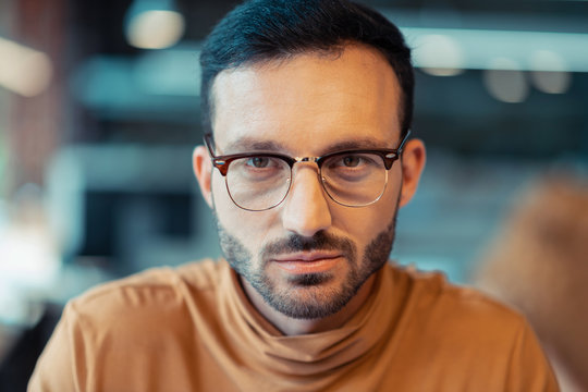 Handsome bearded man wearing glasses feeling excited