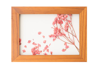 Beautiful pink dried flowers decorated with brown wooden frame isolated on white background,top view
