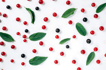 Fruit pattern made of fresh berries and green leaves on white background. Concept of healthy food. Flat lay, top view, copy space