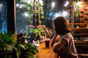 Portrait Asian women Sit alone in coffee shop Past mirror raining