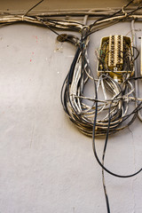 Cable power cords in tangled mess on wall outdoor