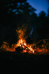 with knife, water bottle and titanium mug near the fire outdoors. bushcraft, adventure, travel, tourism and camping concept.