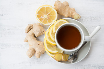 Cup of black tea with ginger and lemon on a light background.Top view.