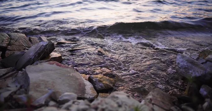 Lake Cachuma, California, USA timelapse of the water of the lake gently splashing rocky shore, trucking left shot