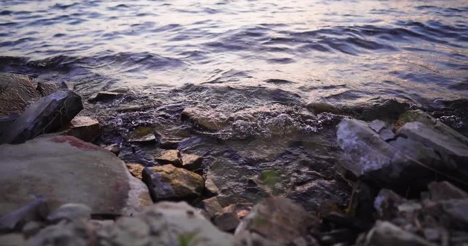 Lake Cachuma, California, USA timelapse of the water of the lake gently splashing rocky shore, trucking left shot