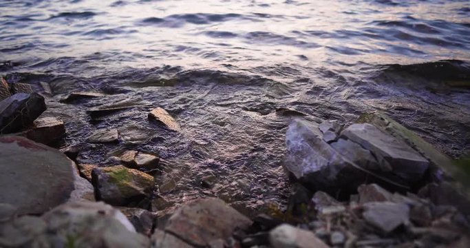 Lake Cachuma, California, USA timelapse of Waves Gently Wash Up Onto rocky shore, trucking left shot