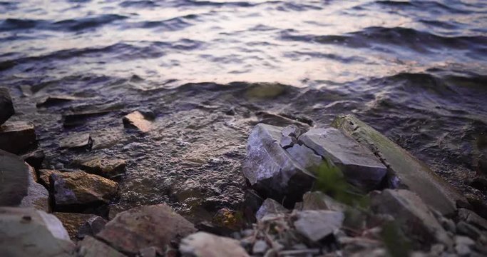 Lake Cachuma, California, USA timelapse of Waves Gently Wash Up Onto rocky shore, trucking left shot