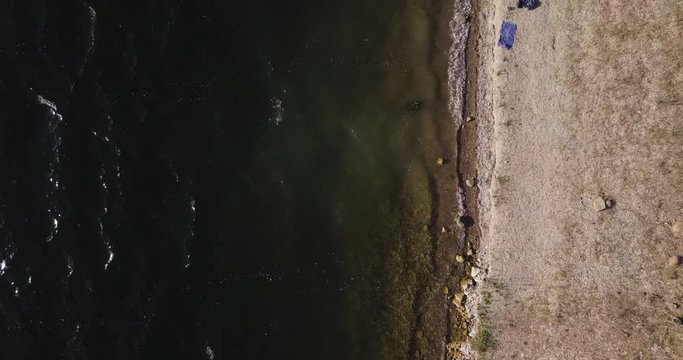 aerial drone overhead dolly in shot of Lake Cachuma, revealing family camping on the lake shore