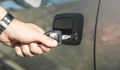 Man with car key. Opening car door