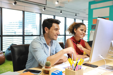 medium shot of caucasian graphic design and coworker in smart casual wear talking and working on...