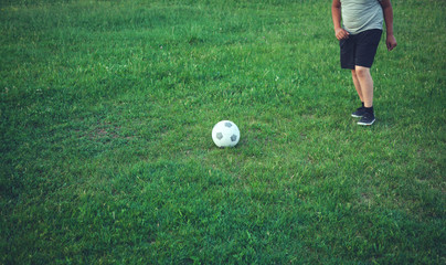 Boy with a soccer ball on a football field.