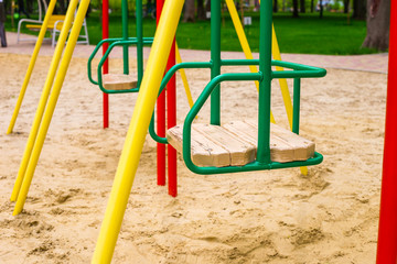 Children's swing at the playground outdoor close-up.