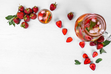 Top view of beautiful mojito jar and glass with strawberries and mint on a light background. Copy space
