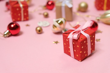 Christmas background with decorations and gift boxes on pink background