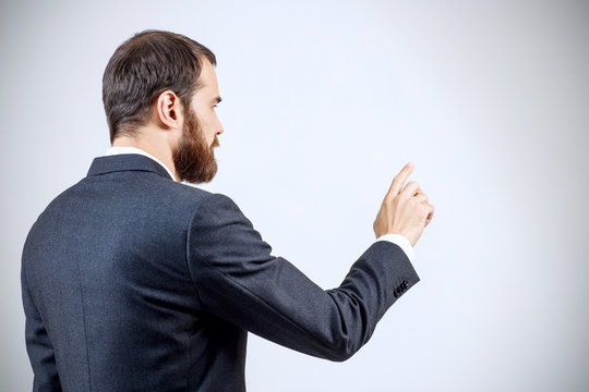 Businessman pointing to something or touching by forefinger.
