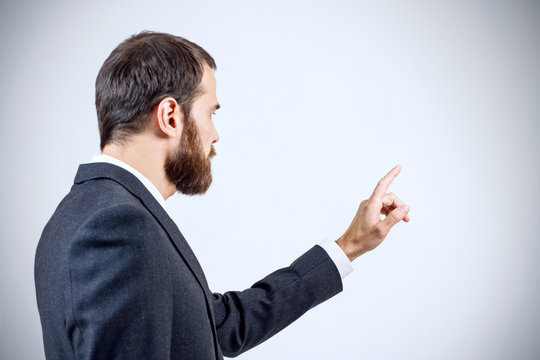 Businessman pointing to something or touching by forefinger.