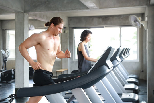 medium shot image of healthy and sexy caucasian muscle man in shirtless who running on excerise machine in gym